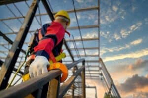 man in safety gear walking up building