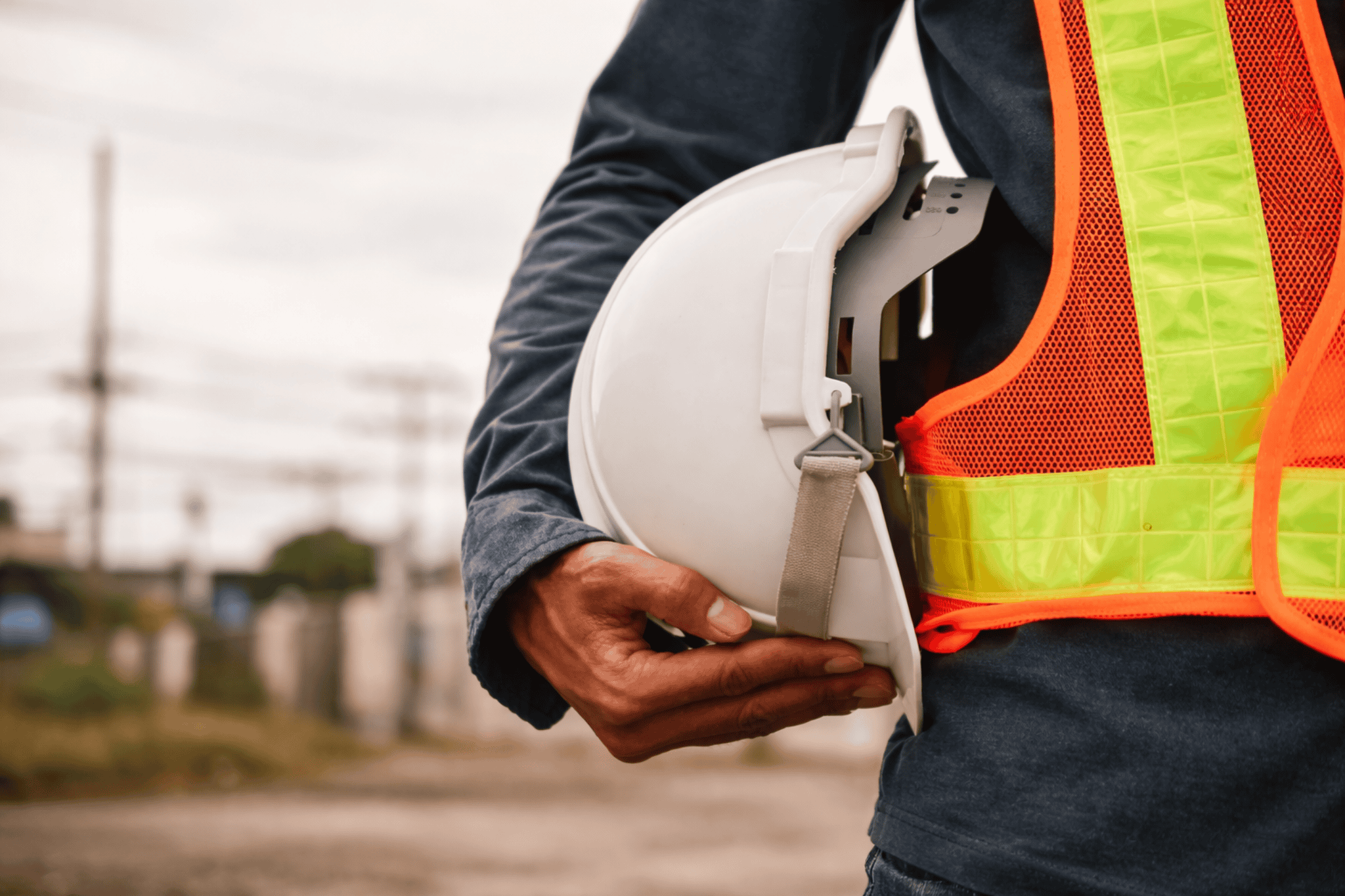 Construction worker holding safety helmet on site